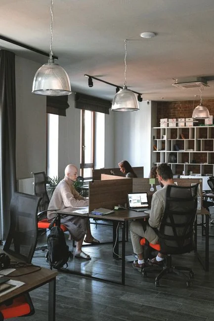 Business professional using a tablet and laptop with a hot drink, focusing on digital content review.